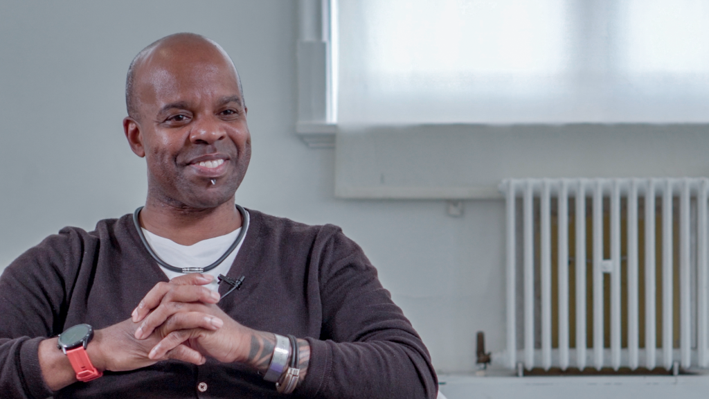 Denzil Bailey sitting with hands clasped.